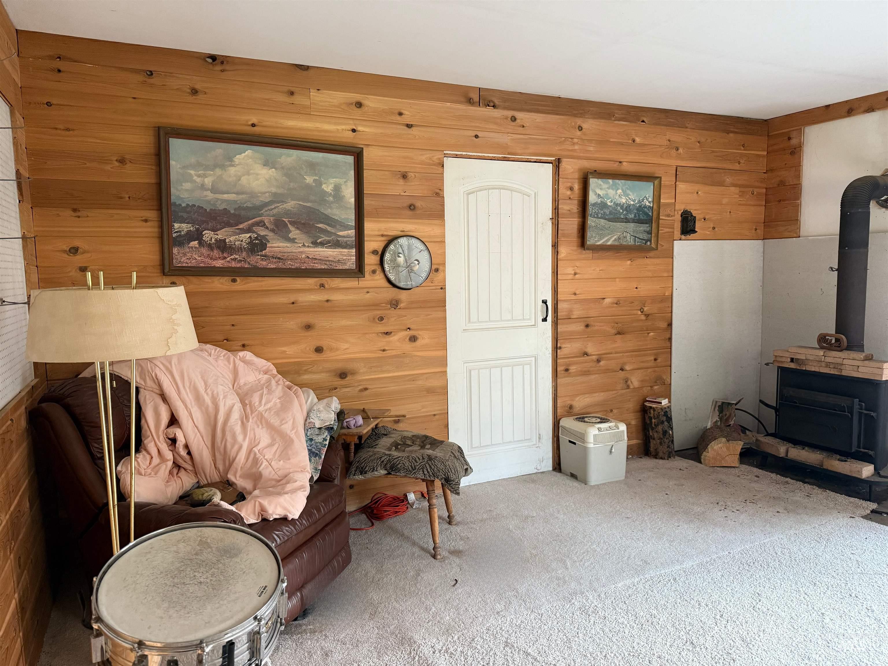 140 Ridgeway Drive Elk City, ID 83525 - Photo 47 of 47 Living area with wood walls, a wood stove, and carpet floors