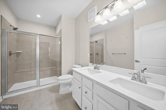 a bathroom with a double vanity sink mirror and toilet
