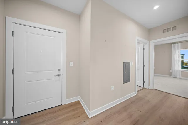 an empty room with wooden floor & closet area