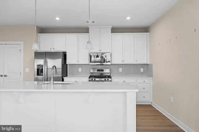 a kitchen with kitchen island white cabinets and refrigerator