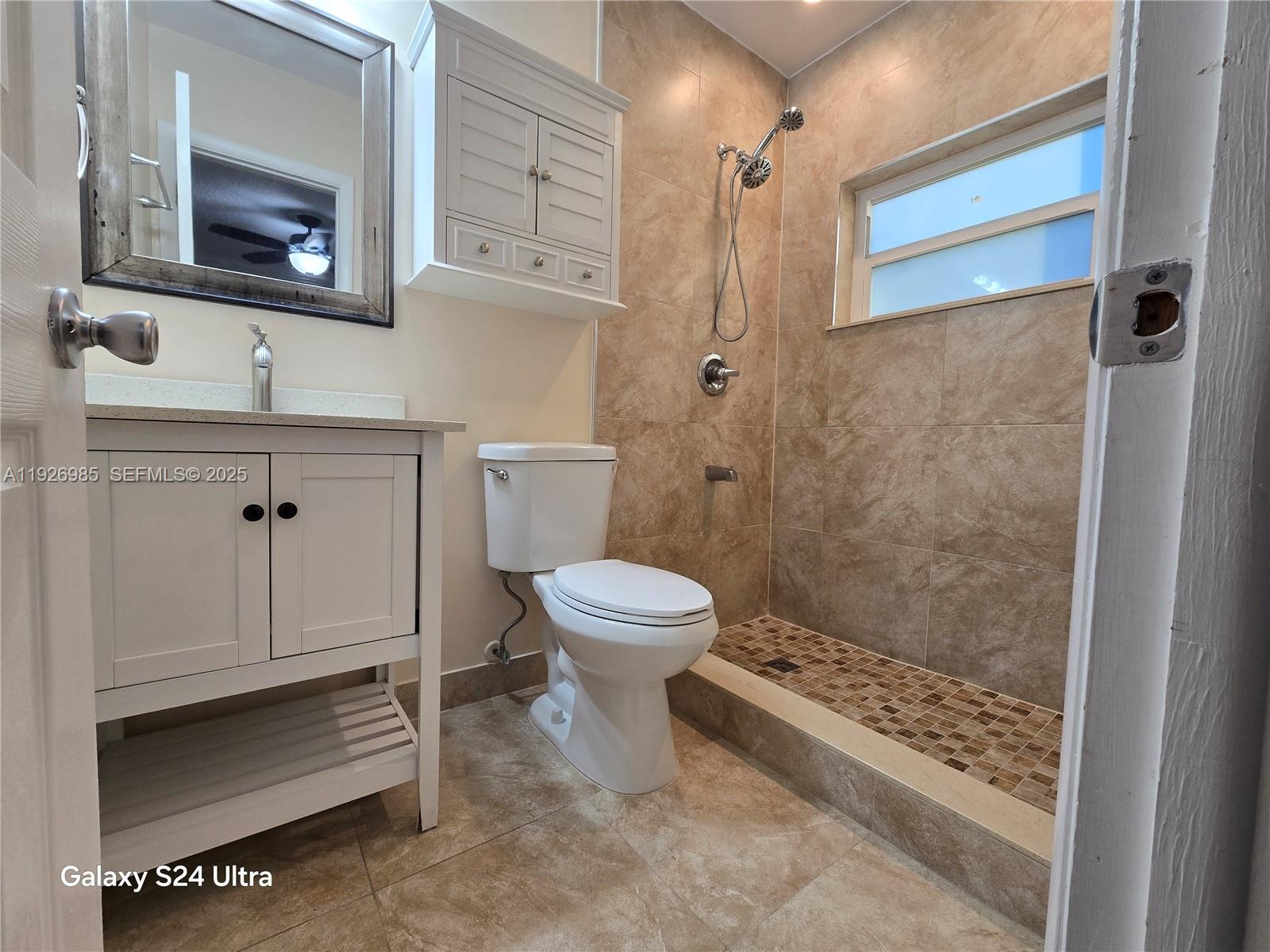 12364 Southwest 266th Terrace, Unit 12364 Homestead, FL 33032 - Photo 15 of 32 a bathroom with a toilet a sink and mirror