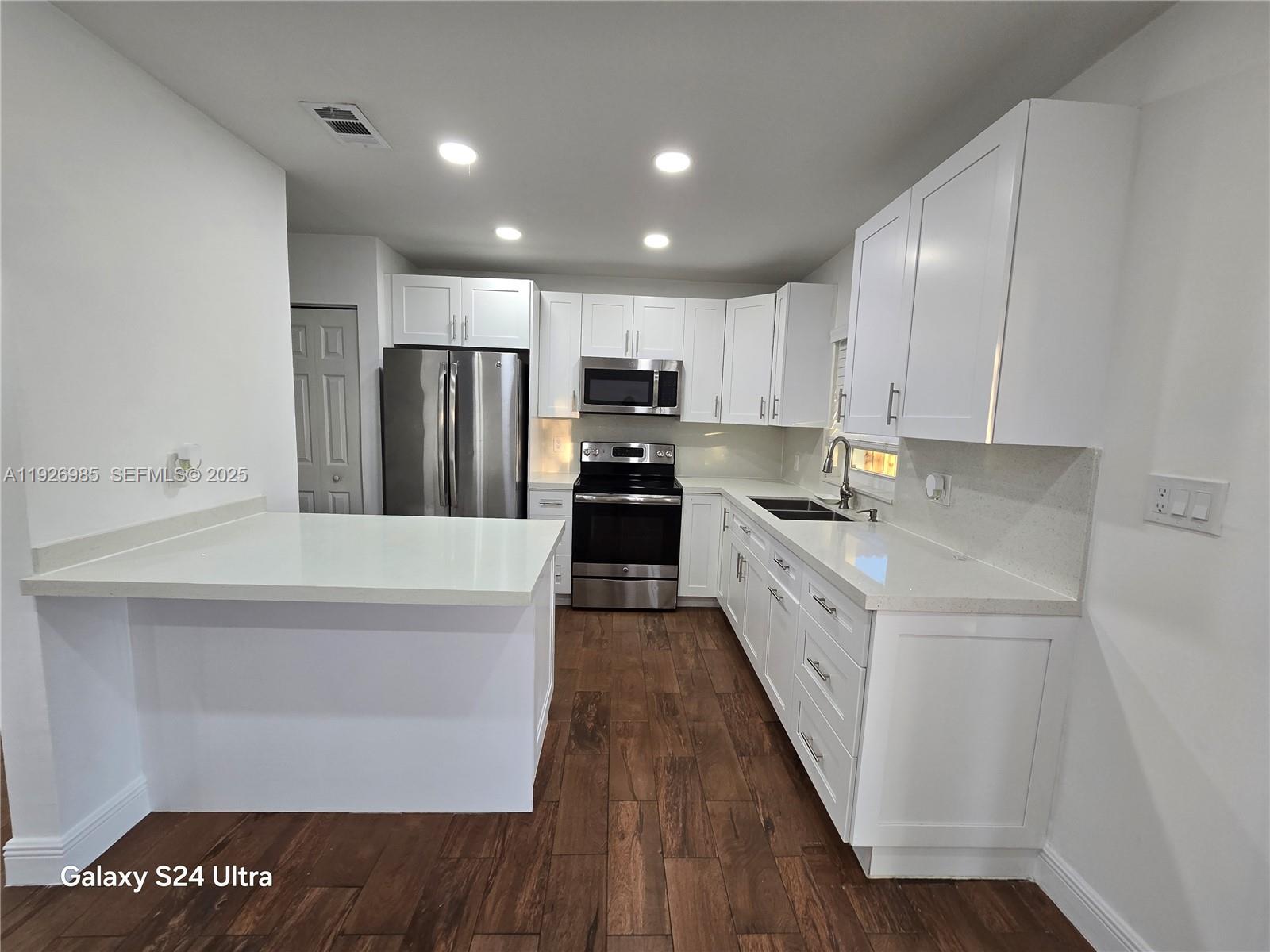 12364 Southwest 266th Terrace, Unit 12364 Homestead, FL 33032 - Photo 19 of 32 a kitchen with kitchen island granite countertop counter top space stainless steel appliances and cabinets