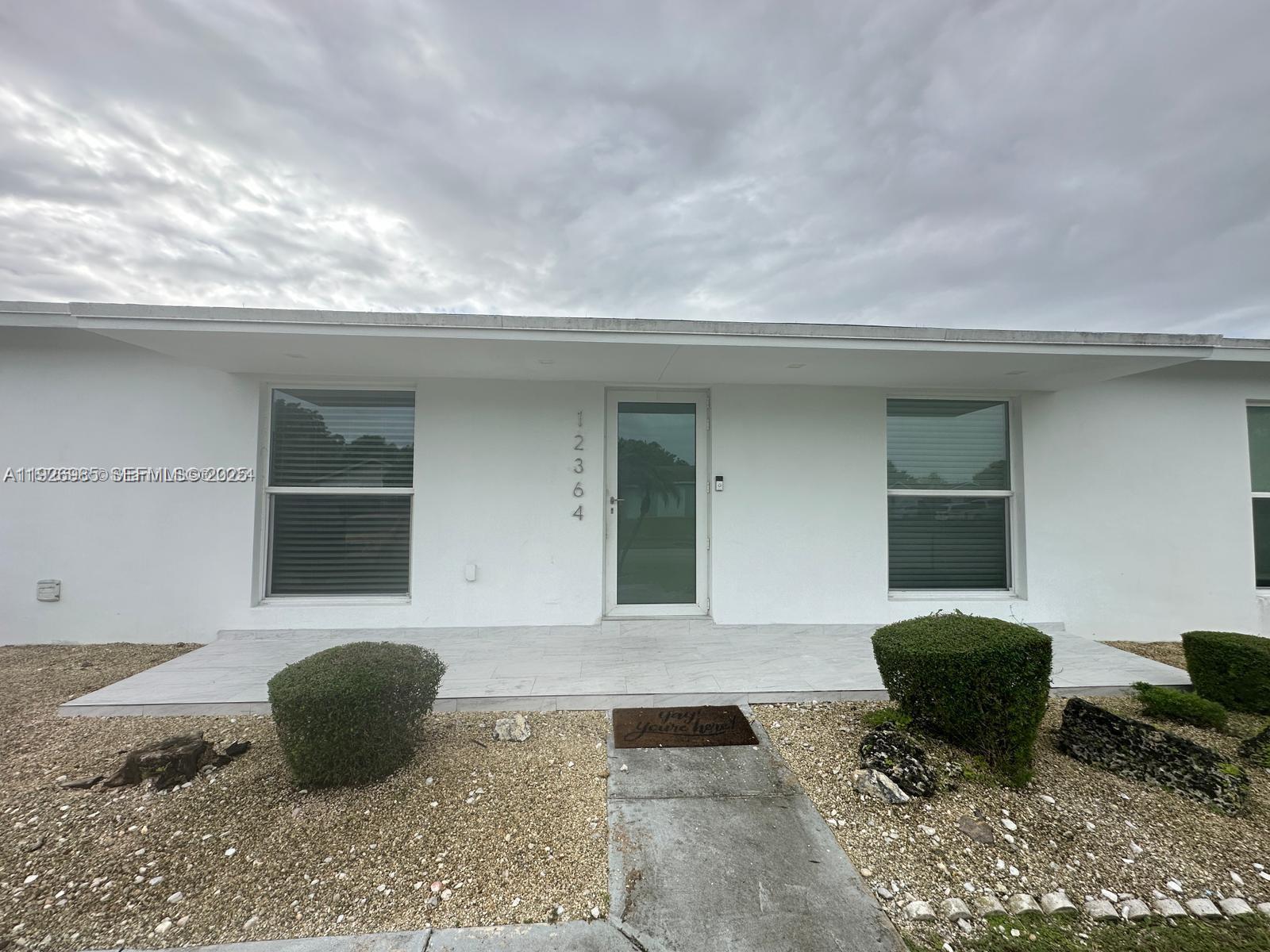 12364 Southwest 266th Terrace, Unit 12364 Homestead, FL 33032 - Photo 2 of 32 a front view of a house with parking space