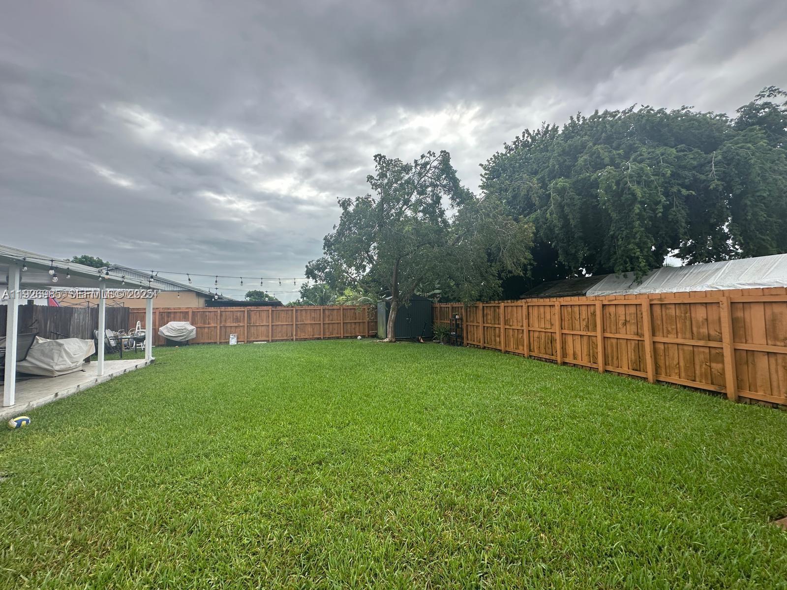 12364 Southwest 266th Terrace, Unit 12364 Homestead, FL 33032 - Photo 3 of 32 a view of a backyard with grass and a garden