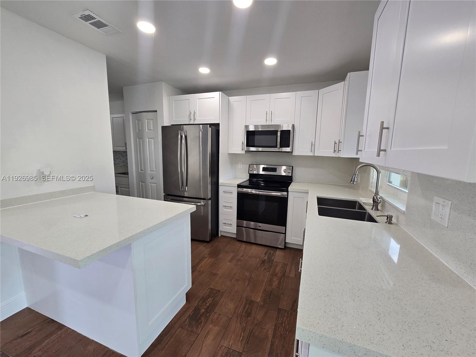 12364 Southwest 266th Terrace, Unit 12364 Homestead, FL 33032 - Photo 31 of 32 a kitchen with stainless steel appliances a refrigerator sink and microwave