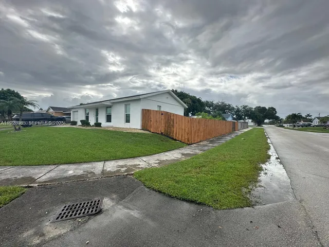 a view of a white house with a yard and garage