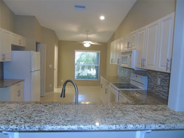 a kitchen with granite countertop a refrigerator and a sink