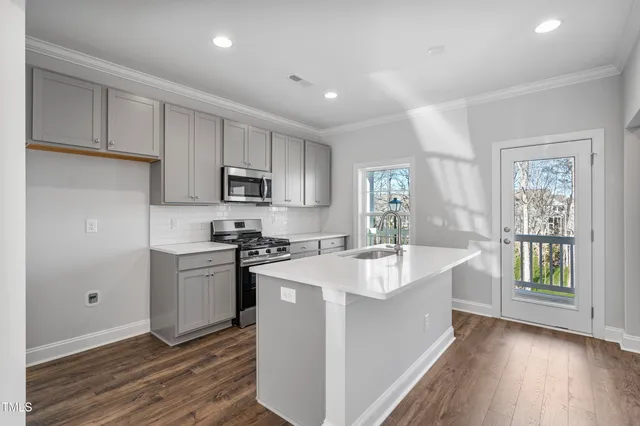 a kitchen with a sink a stove a microwave and cabinets