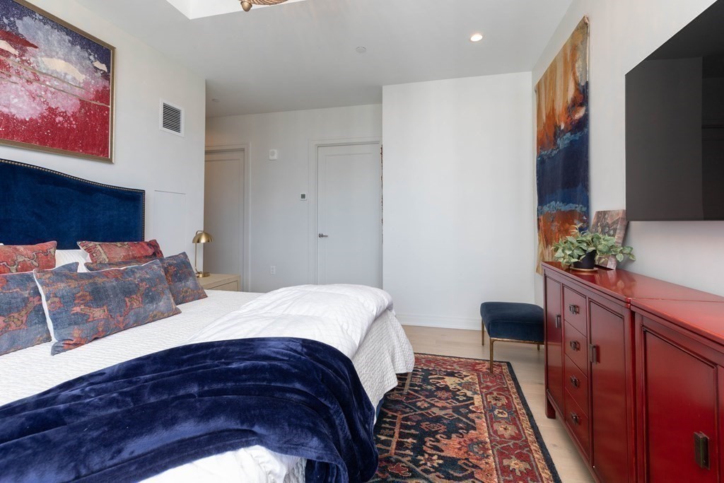 133 Seaport Boulevard, Unit 1908 Boston, MA 02210 - Photo 12 of 34 a bedroom with a bed and a dresser