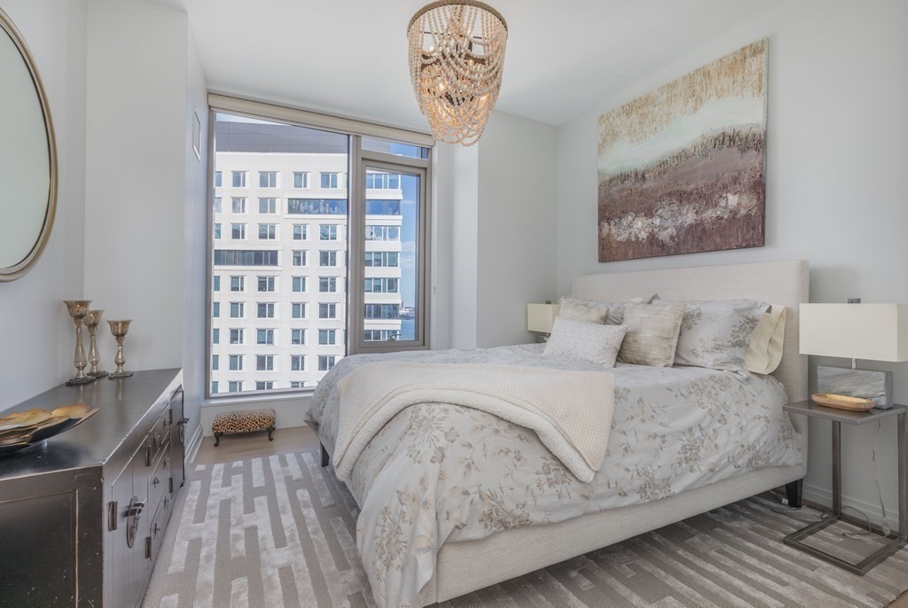 133 Seaport Boulevard, Unit 1908 Boston, MA 02210 - Photo 15 of 34 a bedroom with a bed and a table in it