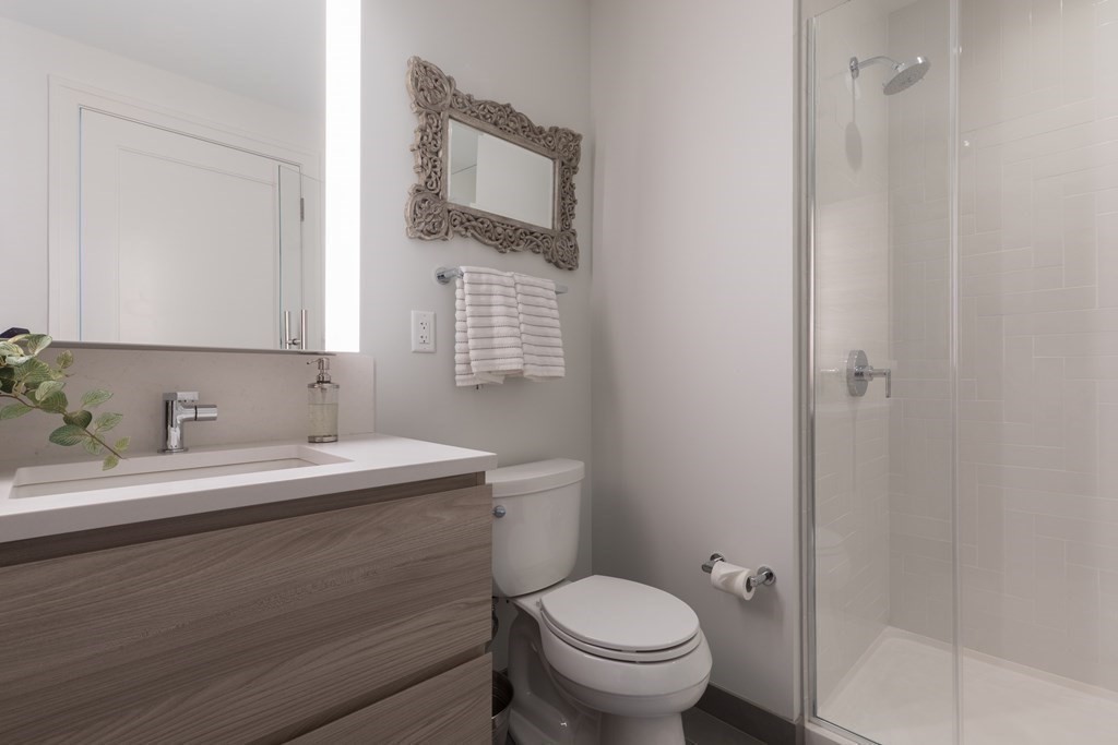 133 Seaport Boulevard, Unit 1908 Boston, MA 02210 - Photo 18 of 34 a bathroom with a toilet sink a mirror and vanity