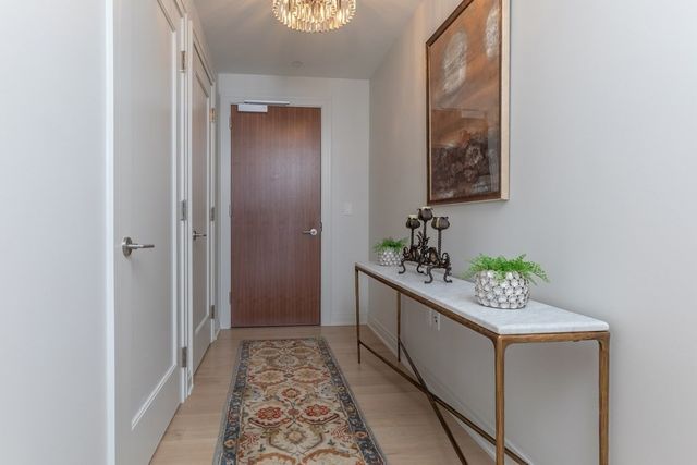 a hallway with painting and a potted plant