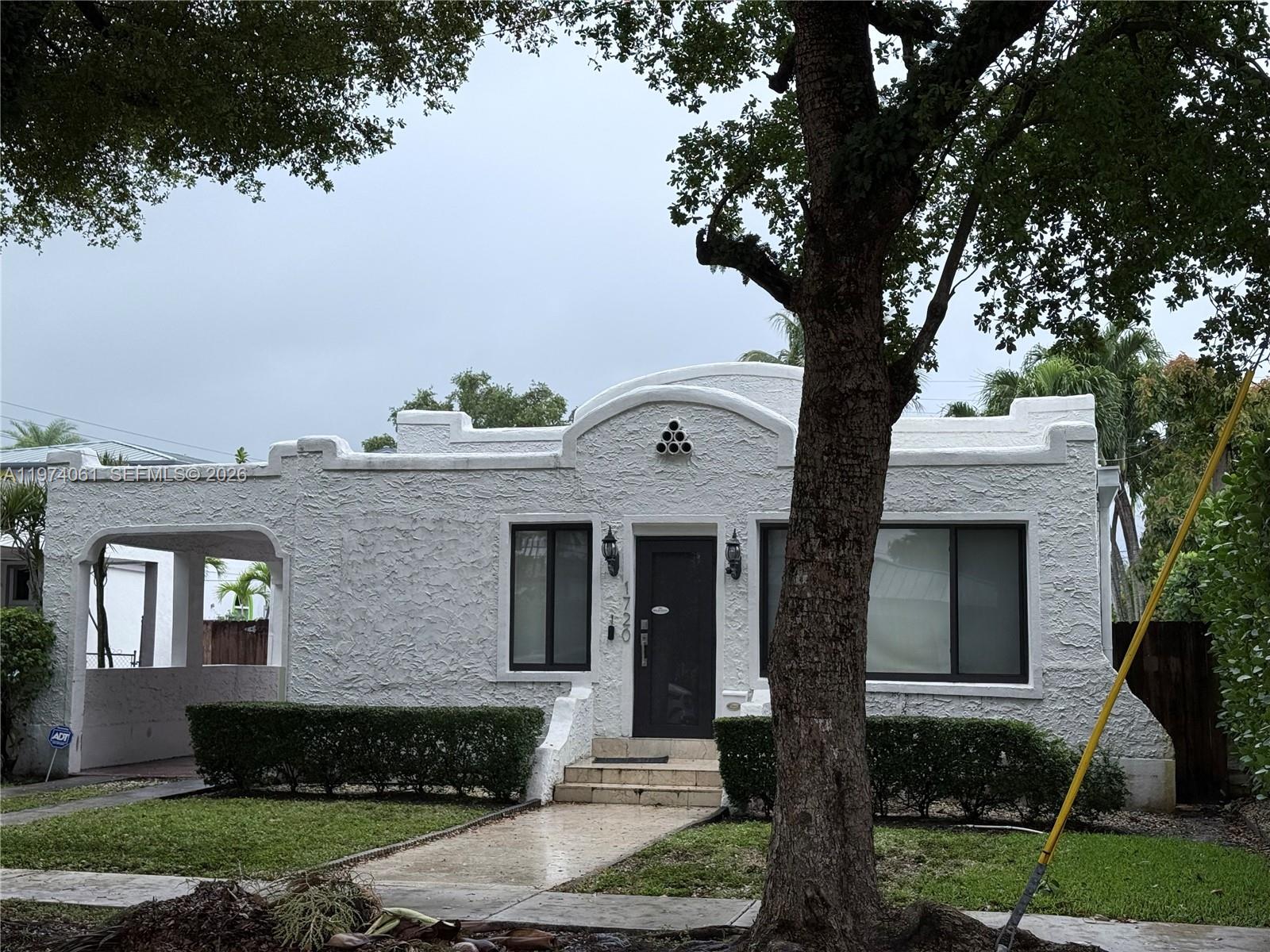 1720 Southwest 22nd Terrace Miami, FL 33145 - Photo 2 of 19 a front view of a house with a yard and garage