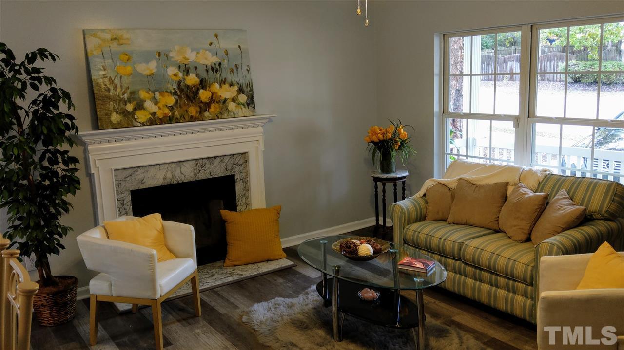 5619 Marthonna Way Raleigh, NC 27616 - Photo 5 of 26 a living room with furniture a flat screen tv and a fireplace