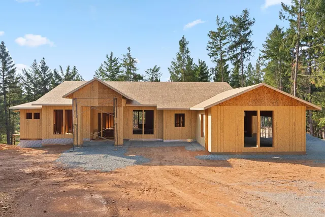 a front view of a house with a yard and trees