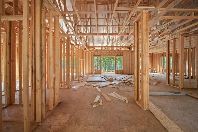 a view of a backyard with large trees and wooden fence