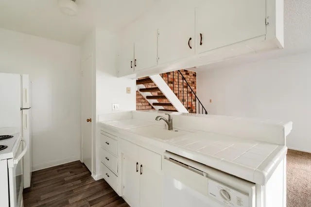 a kitchen with white cabinets and white appliances