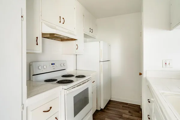 a kitchen with white cabinets and white appliances