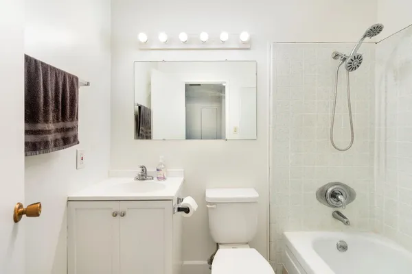 a bathroom with a toilet sink shower and mirror