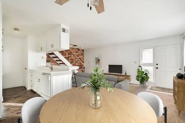 a close view of dining table chairs kitchen appliances and wooden floor