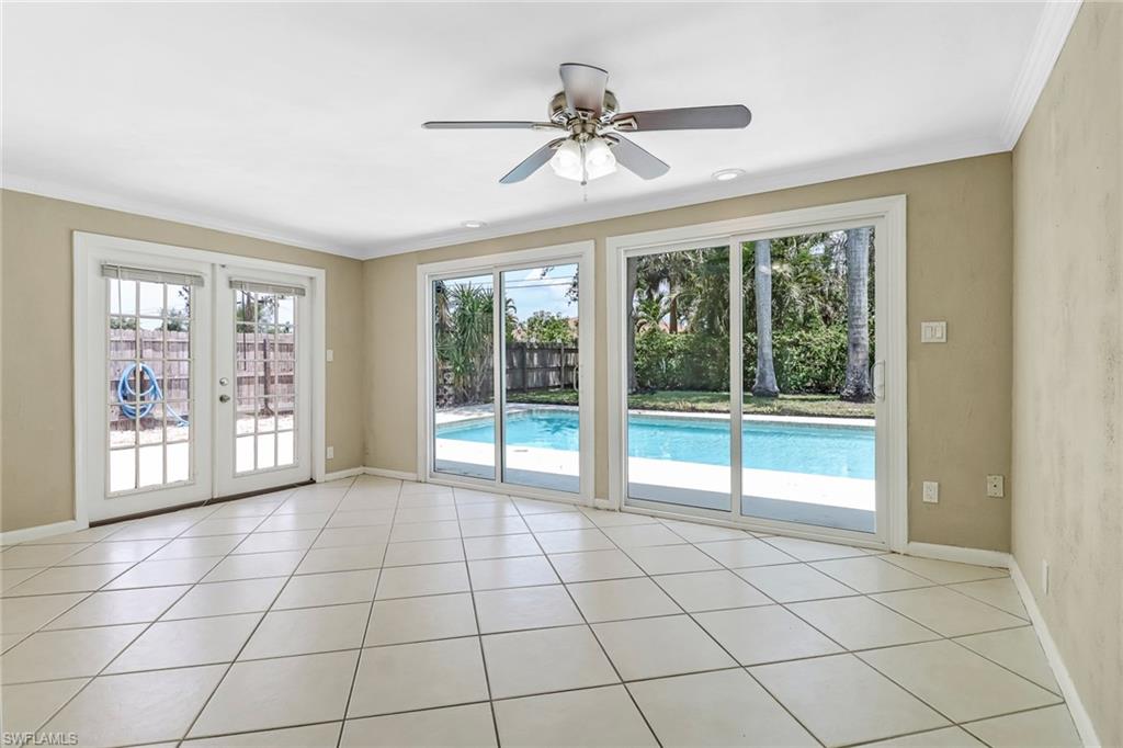 189 Mentor Drive Naples, FL 34110 - Photo 13 of 25 a view of an empty room with a fireplace and windows