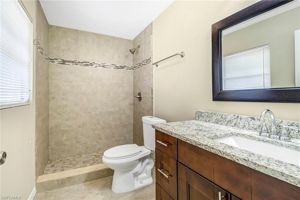 189 Mentor Drive Naples, FL 34110 - Photo 22 of 25 a bathroom with a granite countertop sink toilet and shower