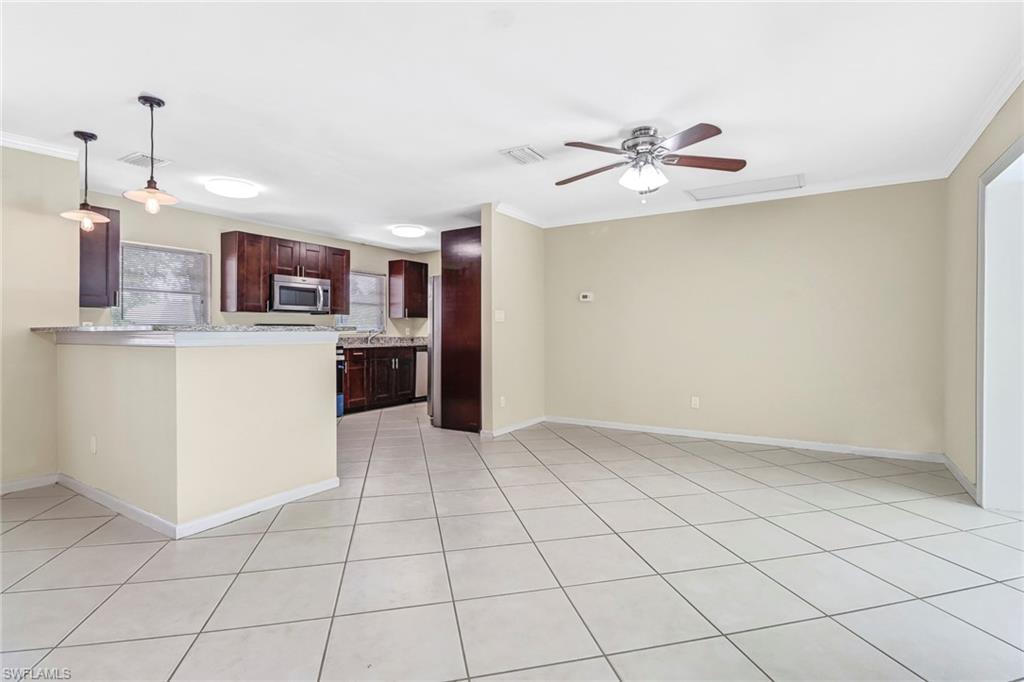 189 Mentor Drive Naples, FL 34110 - Photo 7 of 25 a kitchen with kitchen island granite countertop a refrigerator oven a sink and dishwasher