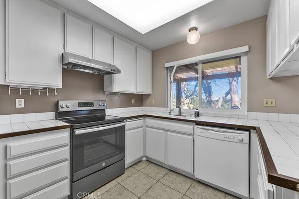 a kitchen with cabinets appliances and a window