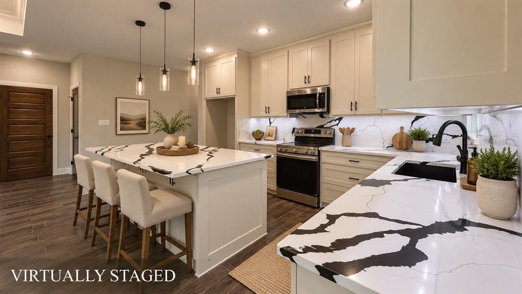302-304 West Pine Street Whitewright, TX 75491 - Photo 14 of 38 Kitchen featuring an island with pendant lighting, stone countertops, stainless steel appliances, a tile backsplash, and wood-finish flooring