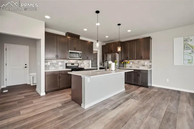 a kitchen with kitchen island a sink stainless steel appliances and cabinets