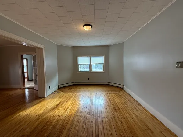 wooden floor in an empty room with a window
