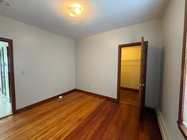 an empty room with wooden floor and closet