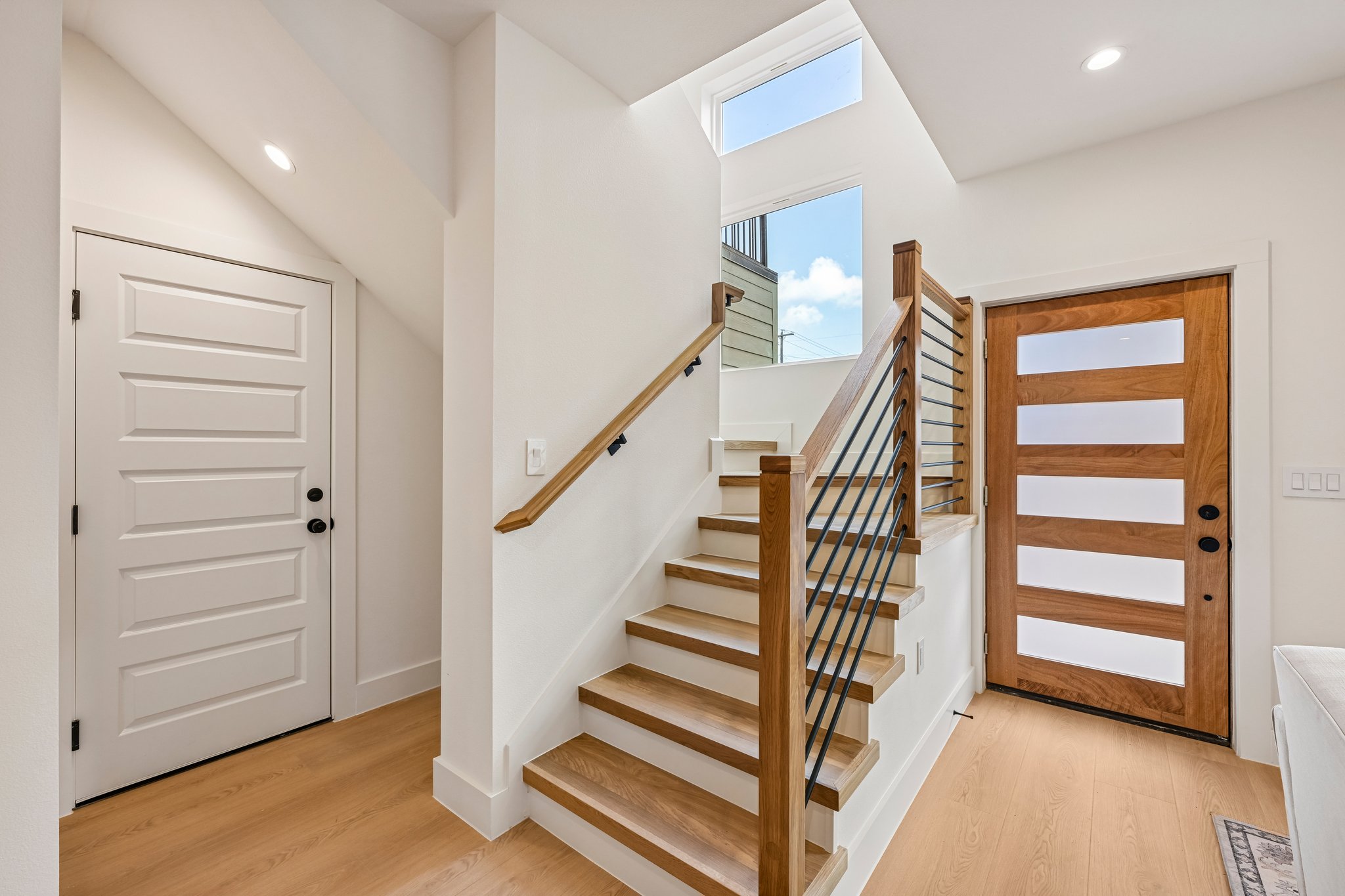 513 West Odell Street, Unit B Austin, TX 78752 - Photo 4 of 38 A well-lit entry features wood look flooring and a contemporary white oak solid wood tread staircase.