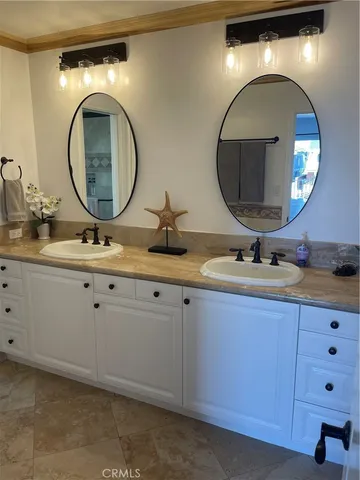 a bathroom with a granite countertop double vanity sink and a mirror