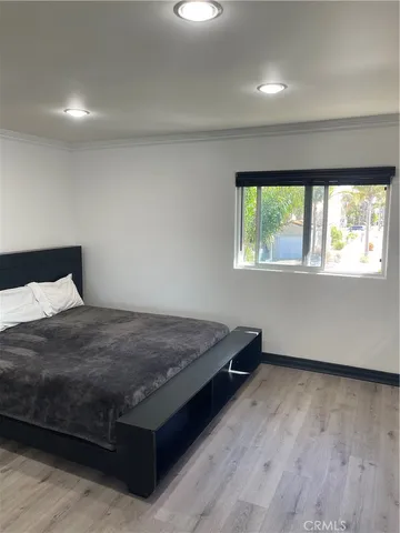 a bed sitting in a bedroom next to a window