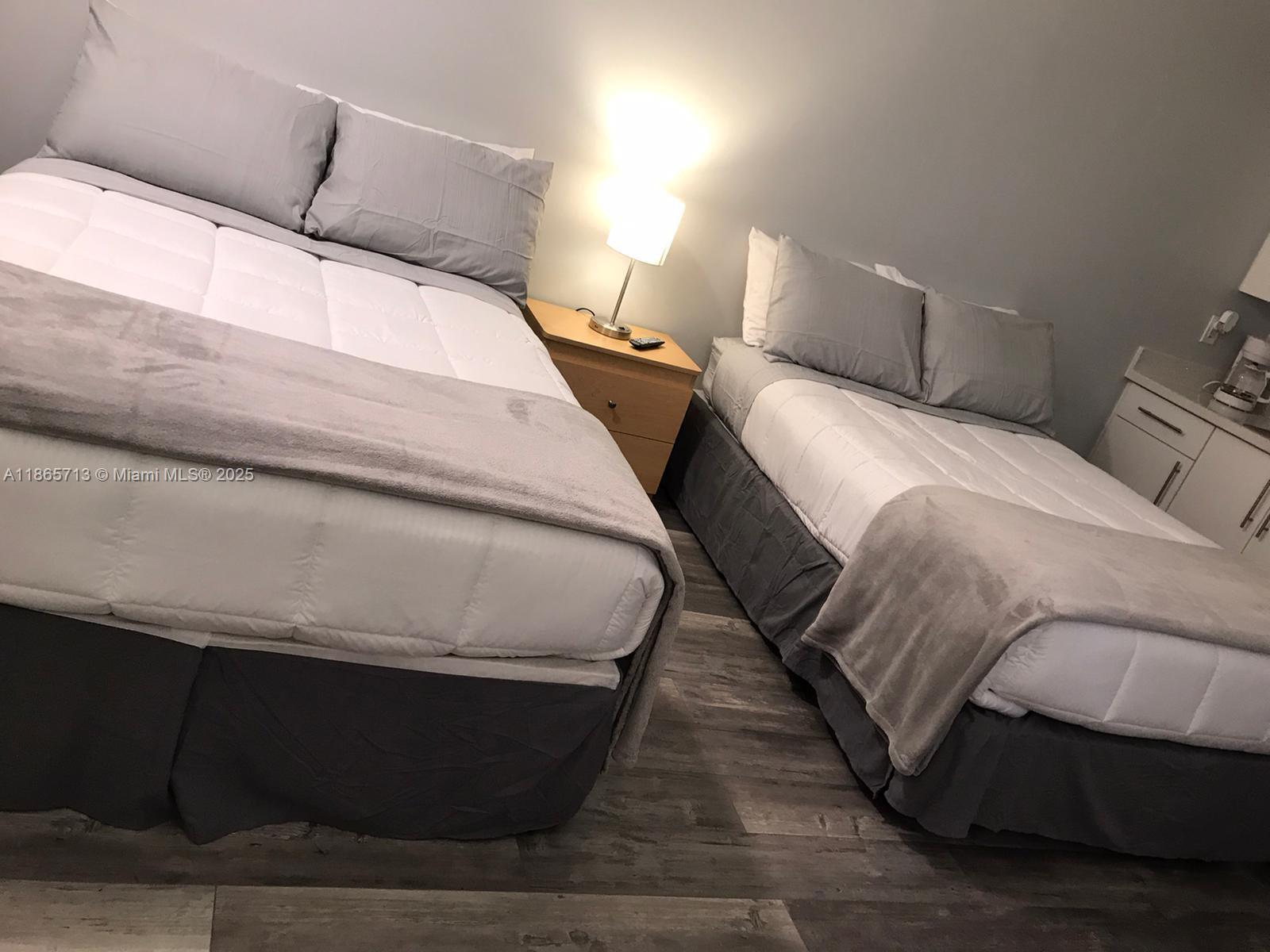 26 Diplomat Parkway, Unit 2215 Hallandale Beach, FL 33009 - Photo 12 of 12 a bed sitting in a bedroom and lamp