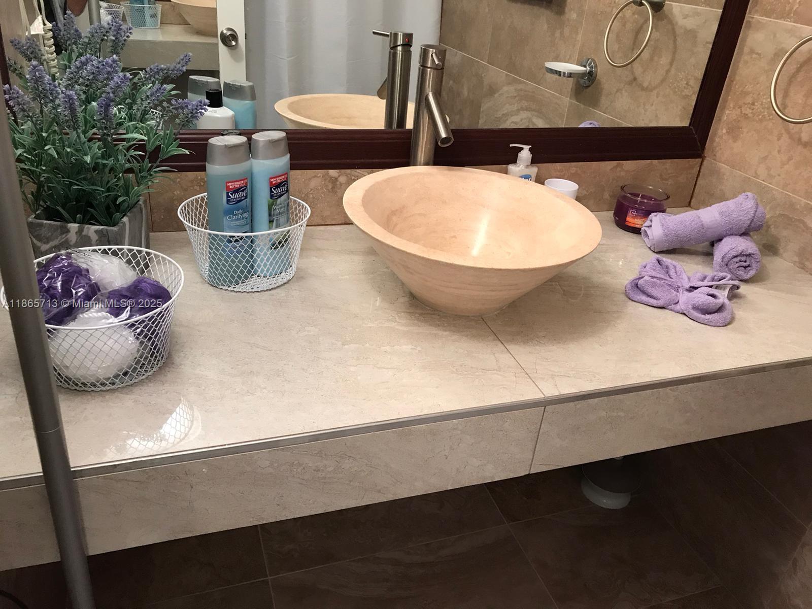 26 Diplomat Parkway, Unit 2215 Hallandale Beach, FL 33009 - Photo 3 of 12 a bathroom with a sink and a mirror