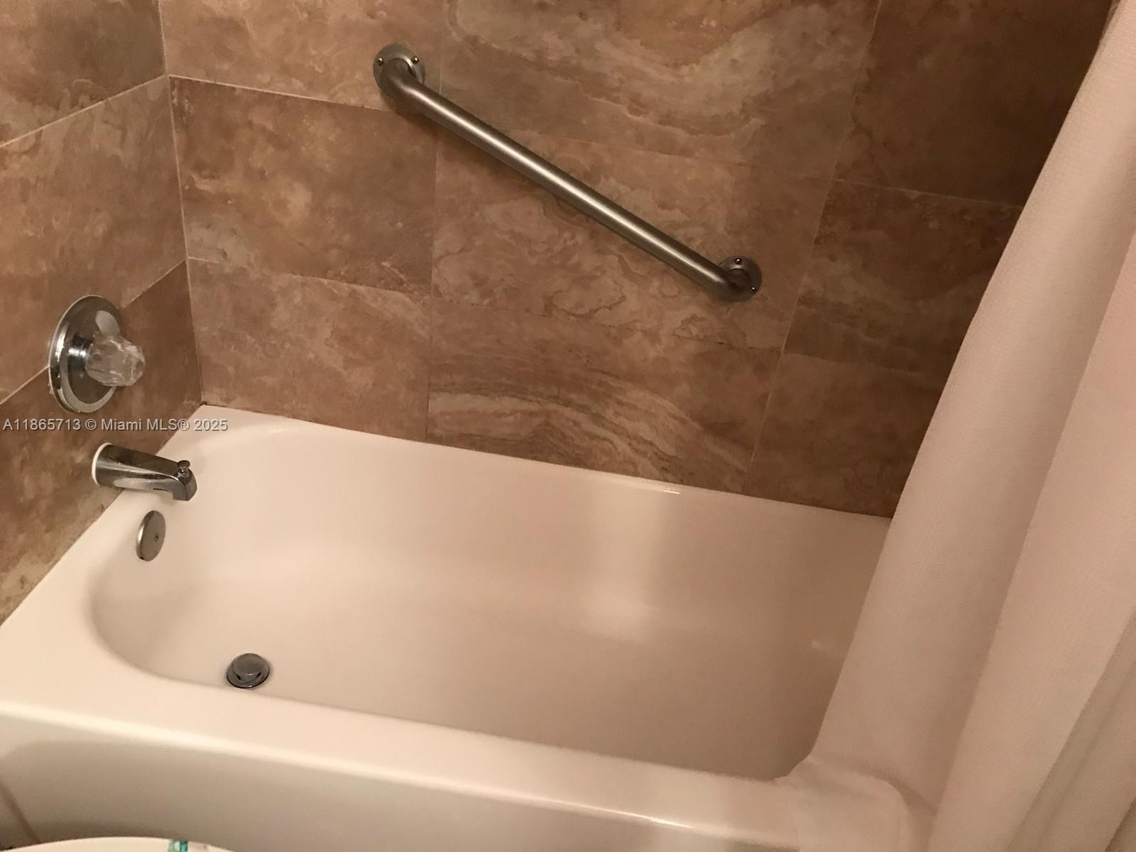 26 Diplomat Parkway, Unit 2215 Hallandale Beach, FL 33009 - Photo 4 of 12 a bathroom with a tub