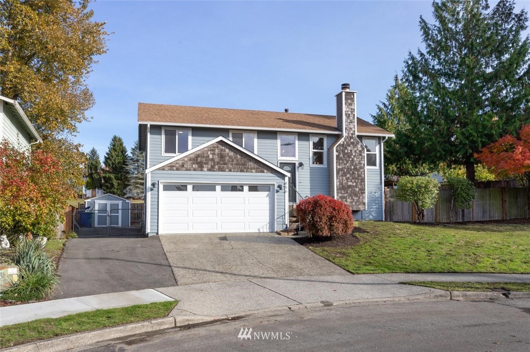 456 Edmonds Court Northeast Renton, WA 98056 - Photo 3 of 25 a front view of a house with a garden and trees