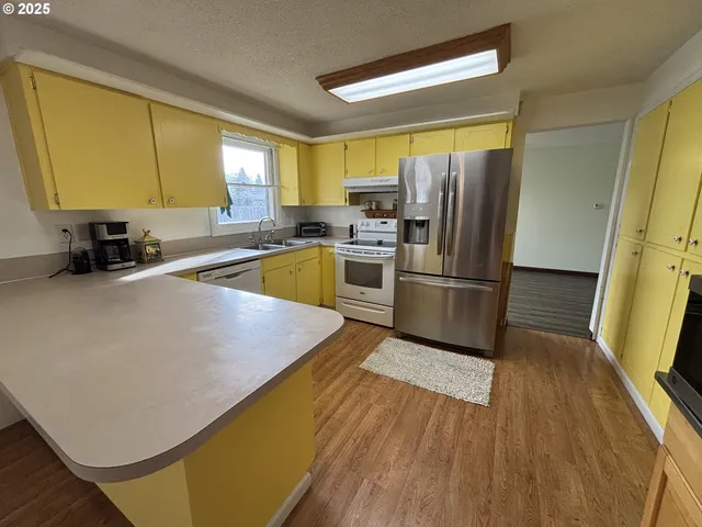 a kitchen with wooden floors and stainless steel appliances