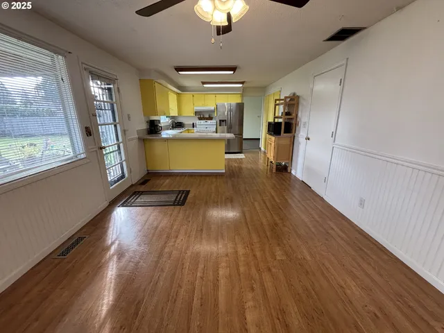 a view of a kitchen with wooden floor and a kitchen