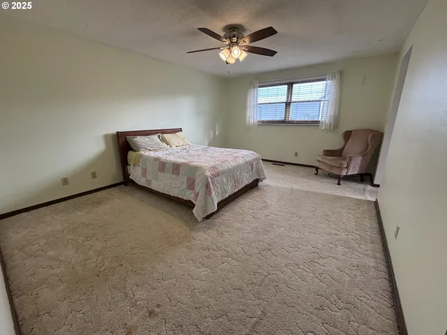 a spacious bedroom with a bed and a chandelier