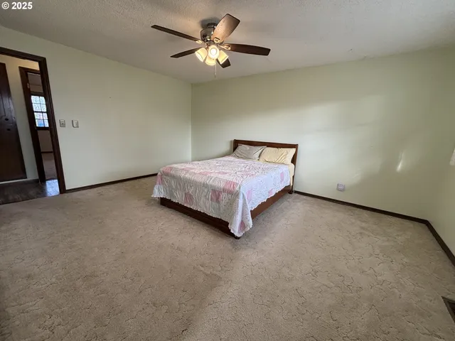 a spacious bedroom with a bed and a chandelier
