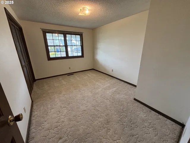 an empty room with windows & cabinet