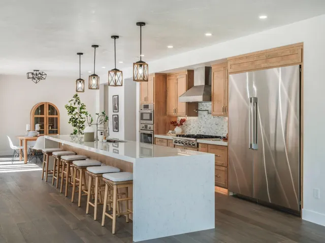 a kitchen with stainless steel appliances granite countertop a refrigerator and a stove top oven