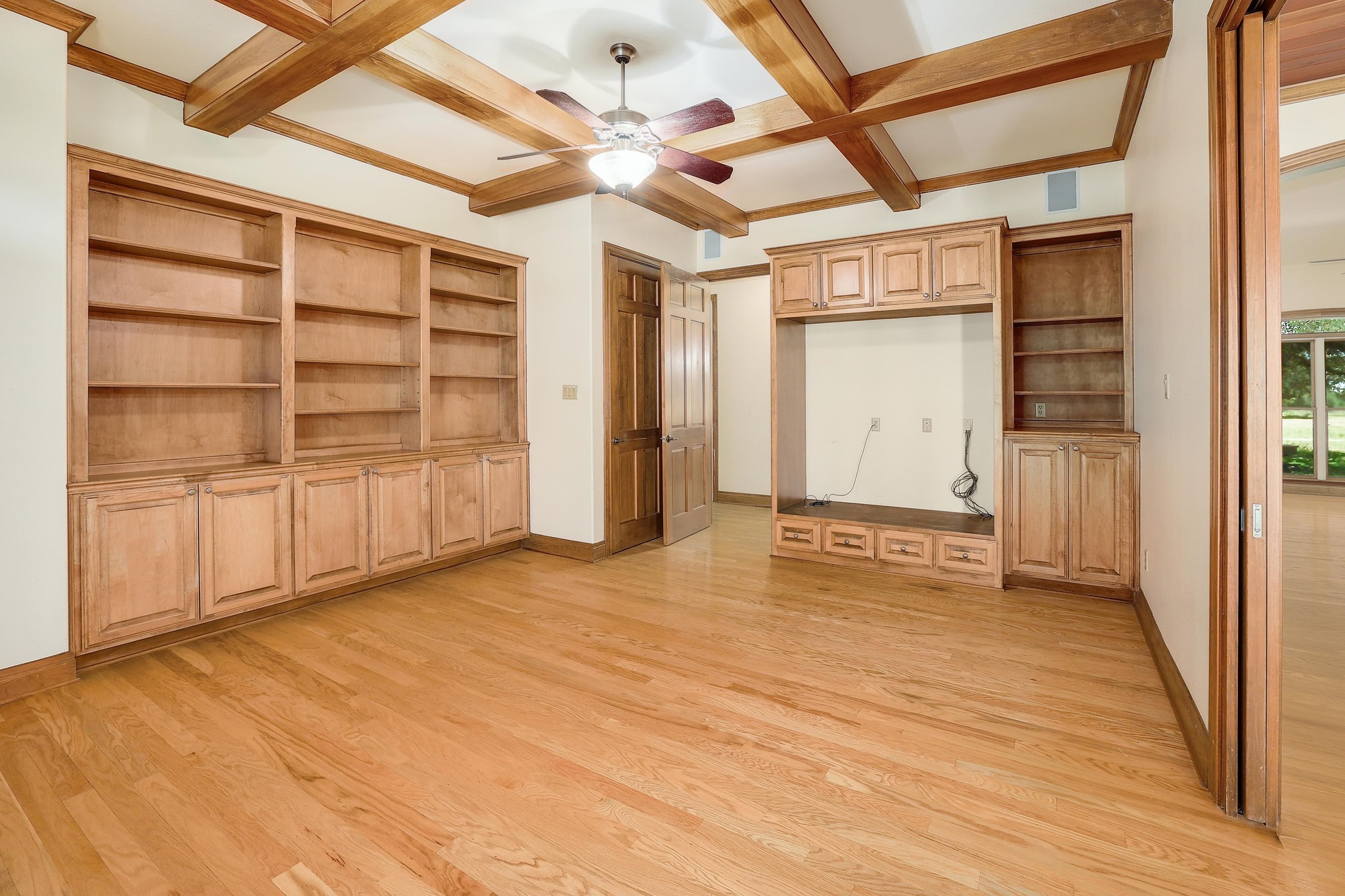 3900 Shell Road Georgetown, TX 78628 - Photo 15 of 40 Unfurnished living room with coffered ceiling, light wood-style floors, beam ceiling, built in features, and ceiling fan