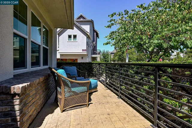 a roof deck with a couch and wooden fence
