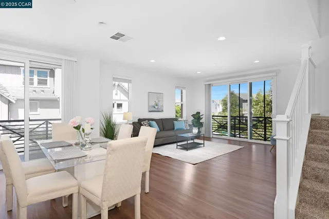 a living room with furniture large window and wooden floor