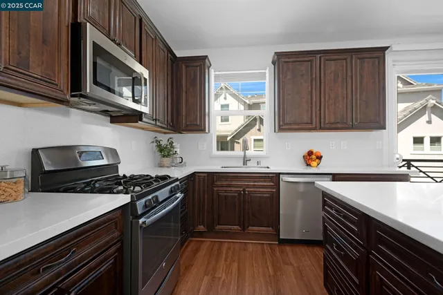 a kitchen with stainless steel appliances a stove sink microwave and cabinets