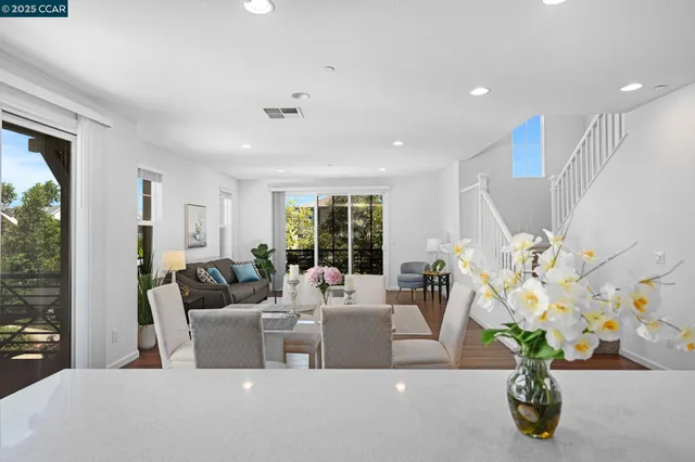a living room with furniture flowerpot and a chandelier